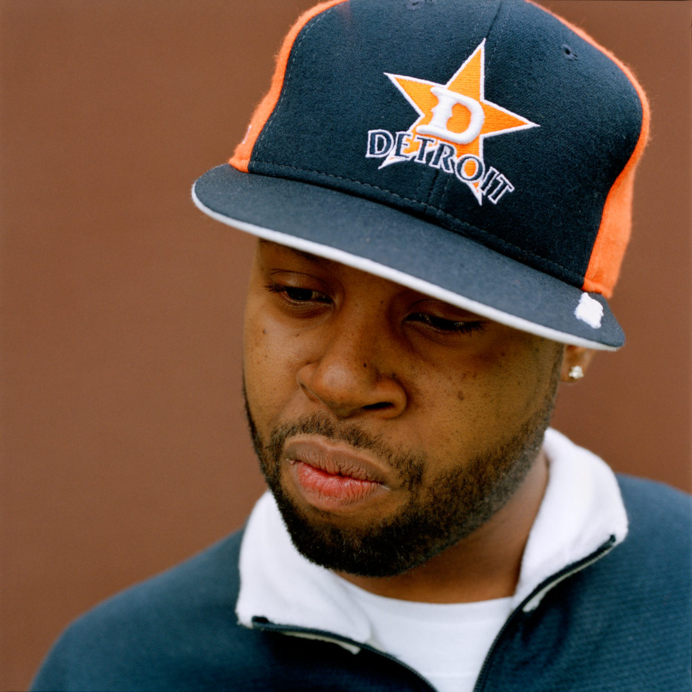 Portrait de J Dilla portant une casquette de Detroit, le regard baissé.